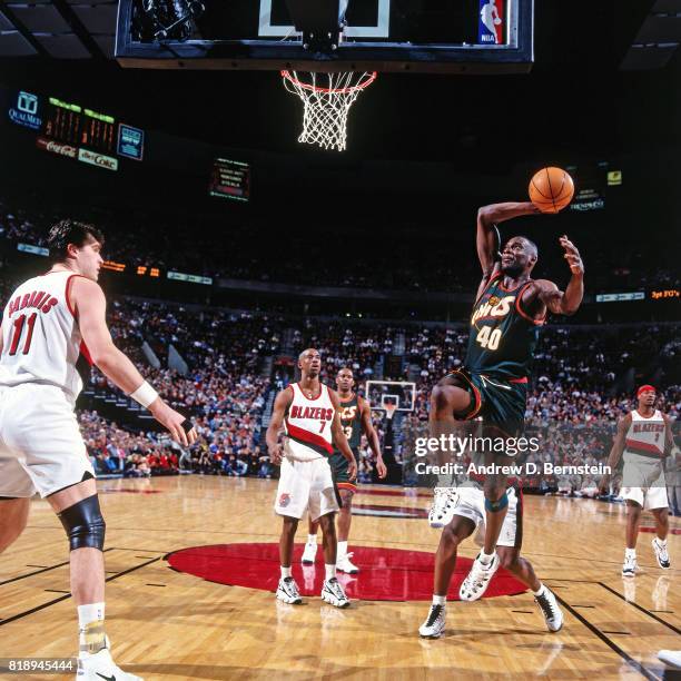 Shawn Kemp of the Seattle SuperSonics dunks against Arvydas Sabonis of the Portland Trail Blazers during a game at the Rose Garden Arena in Portland,...