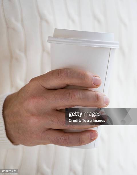 close up of man holding take out coffee - takeaway coffee stockfoto's en -beelden