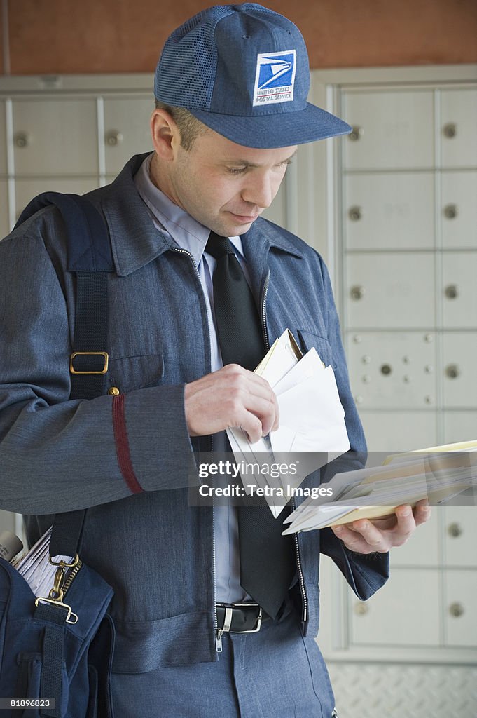 Male postal worker looking at mail