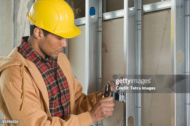 african male electrician installing wires - draadtang stockfoto's en -beelden