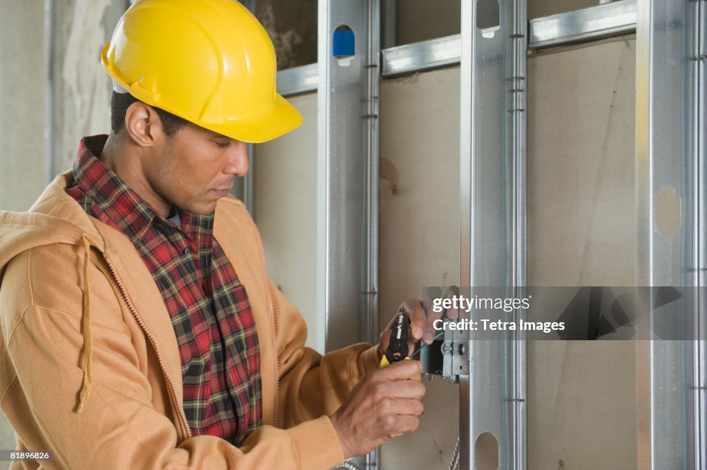 African male electrician installing wires