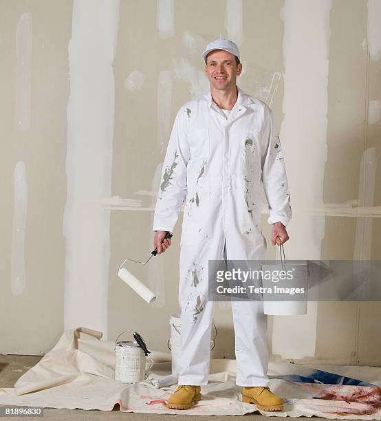 male painter holding paint roller and paint can - white jumpsuit stock pictures, royalty-free photos & images