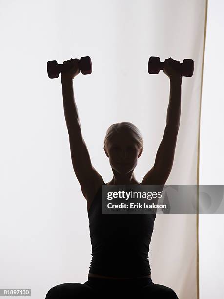 woman lifting weights - woman weight lifting silhouette stock pictures, royalty-free photos & images