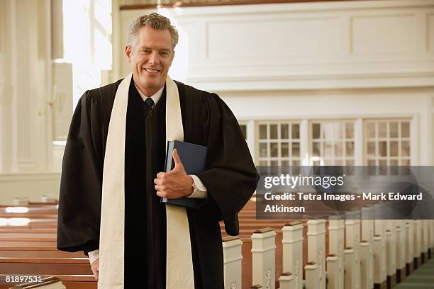 priest standing next to pews - minister clergy photos et images de collection