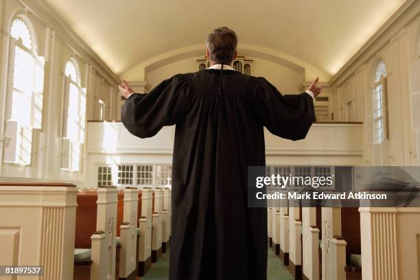priest with arms raised in church - túnica fotografías e imágenes de stock