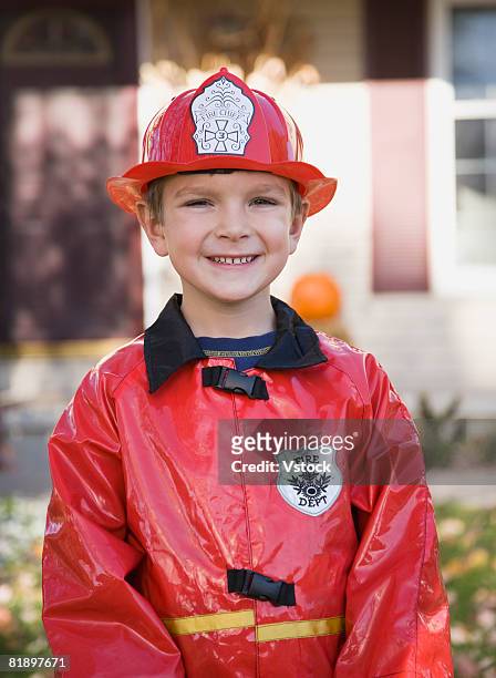 boy dressed in fireman halloween costume - boy fireman costume stock pictures, royalty-free photos & images