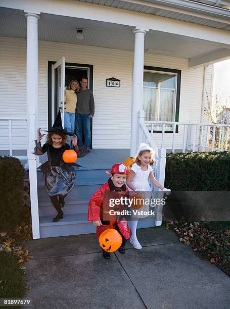 children dressed in halloween costumes leaving house - boy fireman costume stock pictures, royalty-free photos & images