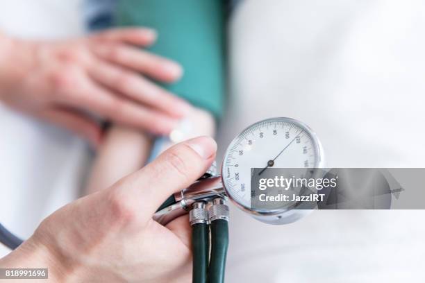 krankenschwester, die den blutdruck des patienten nimmt - blood pressure stock-fotos und bilder
