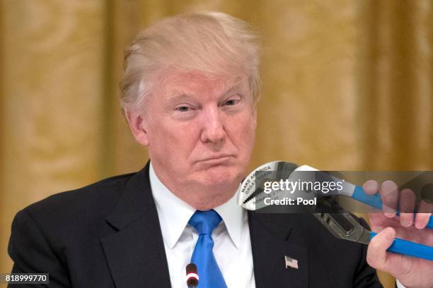 President Donald Trump holds a Channellock tool engraved with his name and "Make America Great Again" during a meeting with US company...