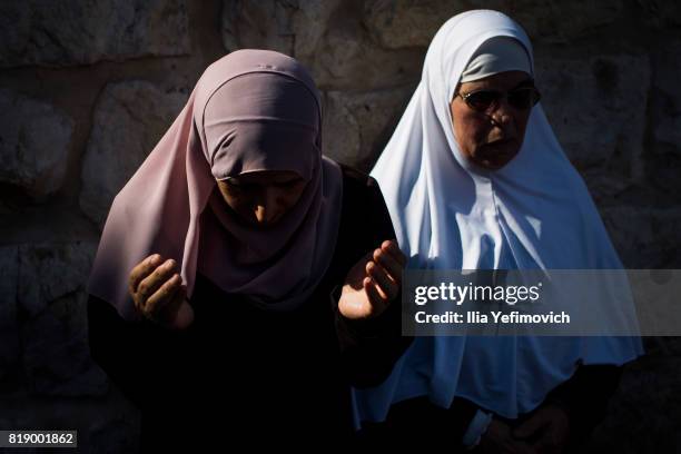 Approximately 4,000 Palestinian Muslims pray outside the entrance to the old city of Jerusalem as it is partially blocked by Israeli Police on July...