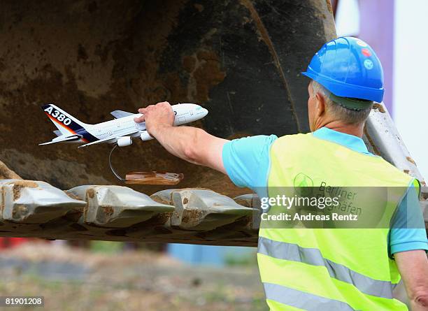 Man holds a model of an Airbus A380 aircraft during an official ceremony of the terminal construction start at Schoenefeld on July 11, 2008 in...