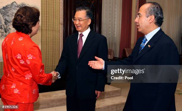 Mexican President Felipe Calderon introduces a member of his delegation to Chinese Premier Wen Jiabao during a meeting at the Zhongnanhai compound on...