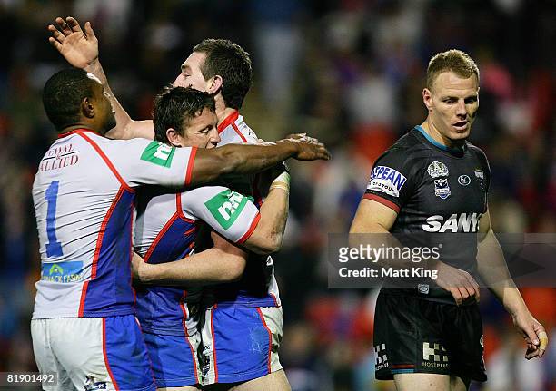Chris Houston of the Knights celebrates with Wes Naiqama and Kurt Gidley after scoring a try as Luke Lewis of the Panthers looks on during the round...