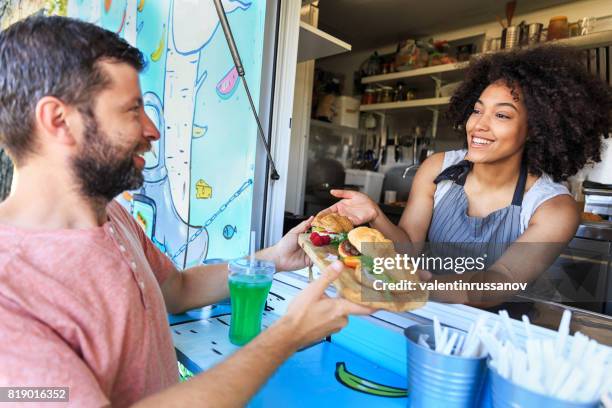 food truck eigenaar serveren broodjes aan klant - booth stockfoto's en -beelden
