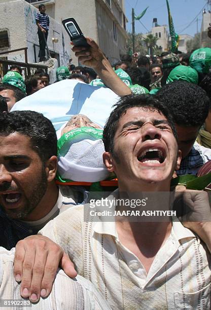 Palestinian mourners carry the body of killed Hamas member, Mahmud Assi, during his funeral in the village of Karawa Bani Hasan near the town of...