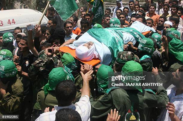 Palestinian mourners carry the body of killed Hamas member, Mahmud Assi, during his funeral in the village of Karawa Bani Hasan near the town of...