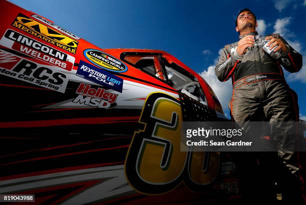 Chris Windom, driver of the Baldwin Brothers/Fox Paving/Central Abrasives Chevrolet, stands next ot his truck during qualifying for the NASCAR...