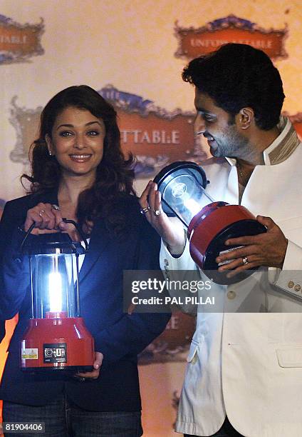 Indian Bollywood film actress Aishwarya Rai Bachchan and husband film actor Abhishek Bachchan pose with Solar Lanterns as they pledge their support...