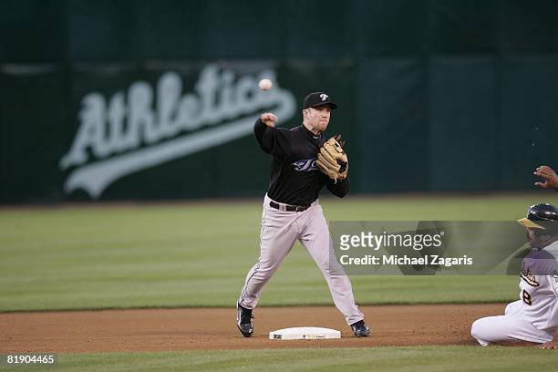 Aaron Hill of the Toronto Blue Jays throws the ball to first base during the game against the Oakland Athletics at McAfee Coliseum in Oakland,...
