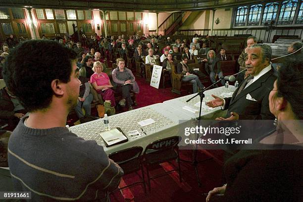 Yelanis Rodriguez, left, a teacher from Washington Heights, listens to House Ways and Means Chairman Charles B. Rangel, D-N.Y., respond to his...