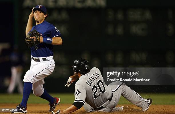 Second baseman Ian Kinsler of the Texas Rangers turns the double play after making the out on Carlos Quentin of the Chicago White Sox in the seventh...