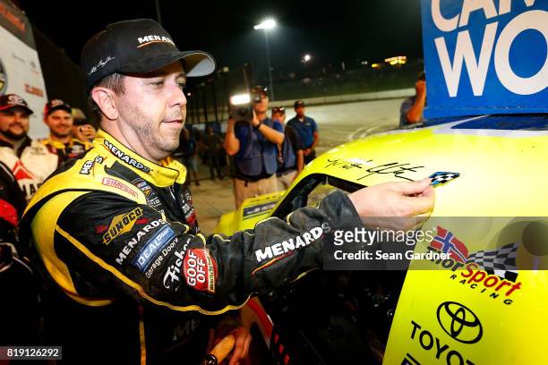 Matt Crafton, driver of the Ideal Door/Menards Toyota, celebrates in victory lane with the winner's decal after winning the NASCAR Camping World...