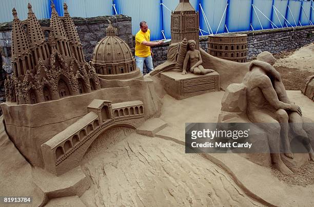 Festival supervisor Alastair Strauss puts the finishing touches to some of the sand sculptures at the Sand Sculpture Festival as it opens to the...