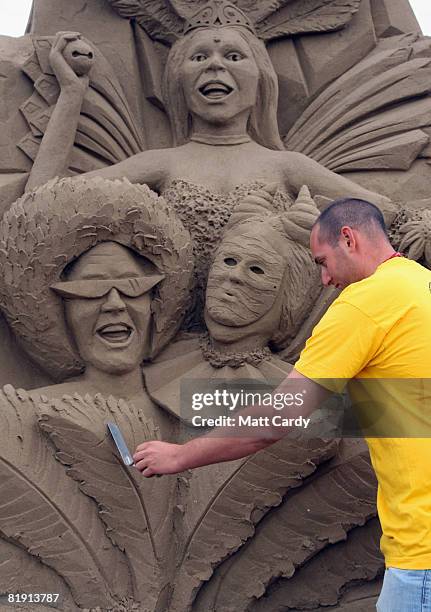 Festival supervisor Alastair Strauss puts the finishing touches to some of the sand sculptures at the Sand Sculpture Festival as it opens to the...