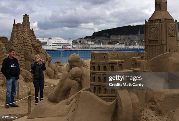 People stop to take a photograph of the sand sculptures at the Sand Sculpture Festival as it opens to the public on July 12 2008 in Weston Super...