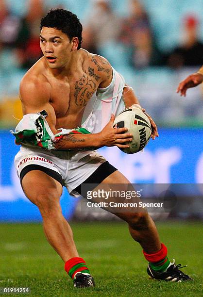 Issac Luke of the Rabbitohs passes the ball waering a torn jersey during the round 18 NRL match between the South Sydney Rabbitohs and the Parramatta...