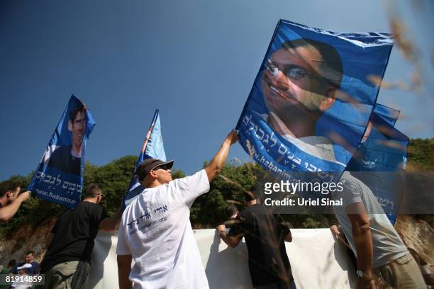 Israelis carry flags with portraits of captured soldiers Ehud Goldwasser, Ehud Goldwasseras and Gilad Schalit as friends and family gather for a...