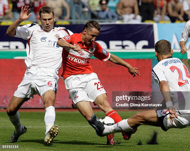 Vladimir Bystrov of FC Spartak Moscow competes for the ball with Aleksei Berezutskiy and Vasili Berezutskiy of PFC CSKA Moscow during the Russian...
