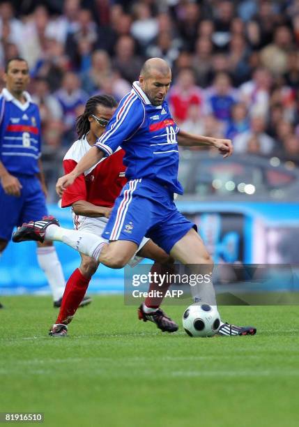 French Zinedine Zidane vies with Dutch Edgar Davids during their football exhibition match between France's 1998 World Cup champions and a world...