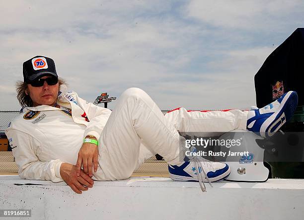 Recording artist and actor Dwight Yoakam kicks back on pit road before taking a ride with NASCAR legend Richard Petty prior to the NASCAR Sprint Cup...