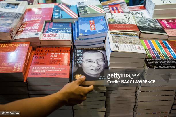 Visitor looks at a biography of the late Chinese Noble laureate Liu Xiaobo at the International Book Fair in Hong Kong on July 20, 2017. This year's...