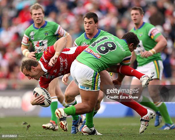 Mark Gasnier of the Dragons is tackled by Neville Costigan of the Raiders during the round 18 NRL match between the St George Illawarra Dragons and...