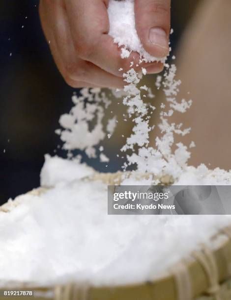 Sumo wrestler grabs some salt to toss into the ring at the Nagoya Grand Sumo Tournament in Nagoya, central Japan, on July 18, 2017. About 40 to 50...