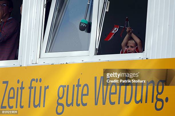 Fan cheers out of a window during a friendly match between SV Lippstadt 08 and FC Bayern Munich at the 'Am Waldschloesschen' stadium on July 13, 2008...