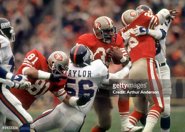 San Francisco running back Roger Craig tries to run through New York Giants Hall of Fame linebacker Lawrence Taylor as tight end Russ Francis and...