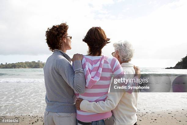 three generations of women looking out to sea - grey hair back stock pictures, royalty-free photos & images