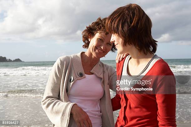 mother and teenage daughter on beach - waiheke island stock pictures, royalty-free photos & images