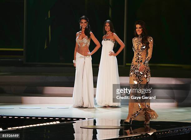 Miss Mexico Elisa Najeram and Miss Russia Vera Krasova stand by as Miss Dominian Republic Marianne Cruz Gonzalez takes her final walk dressed in...