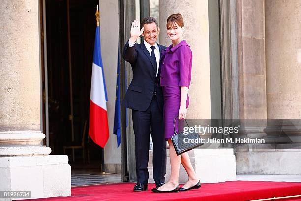 French President Nicolas Sarkozy and his wife Carla Bruni-Sarkozy arrive in the courtyard of the Elysee for the garden party following the Bastille...
