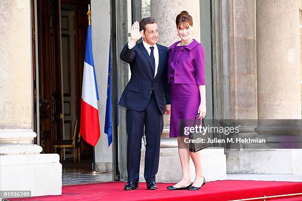 French President Nicolas Sarkozy and his wife Carla Bruni-Sarkozy arrive in the courtyard of the Elysee for the garden party following the Bastille...