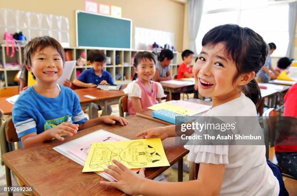 Children smile as they receive their first term school report on July 20, 2017 in Osaka, Japan. Most schools in Kansai region finish their first term...
