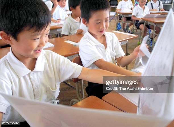 Children smile as they receive their first term school report on July 20, 2017 in Osaka, Japan. Most schools in Kansai region finish their first term...