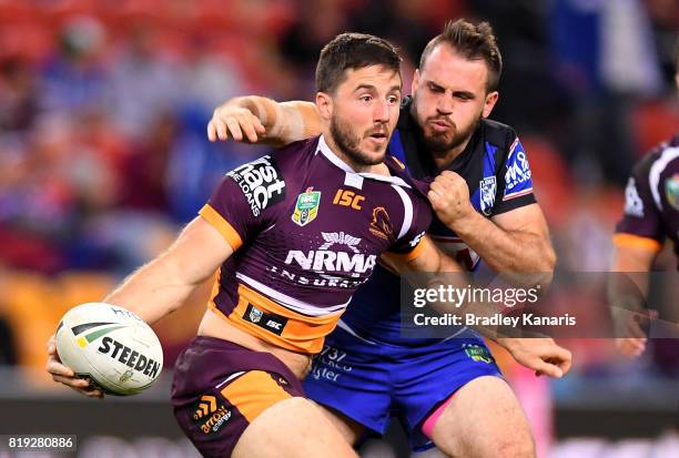 Ben Hunt of the Broncos offloads as he is pressured by the defence of Josh Reynolds of the Bulldogs during the round 20 NRL match between the...