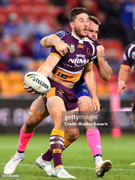 Ben Hunt of the Broncos offloads as he is pressured by the defence of Josh Reynolds of the Bulldogs during the round 20 NRL match between the...