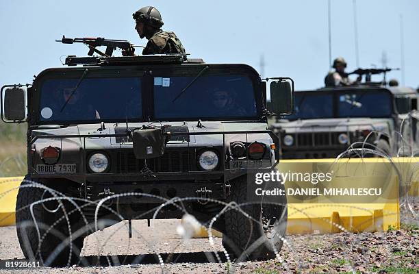 Romanian soldiers secure the area at a newly installed check-point at Babadag training facility in the county of Tulcea, during a joint task...