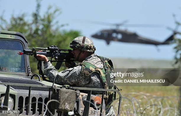 Military takes aim as a medevac helicopter is seen on the background at Babadag training facility in the county of Tulcea, during a joint task...